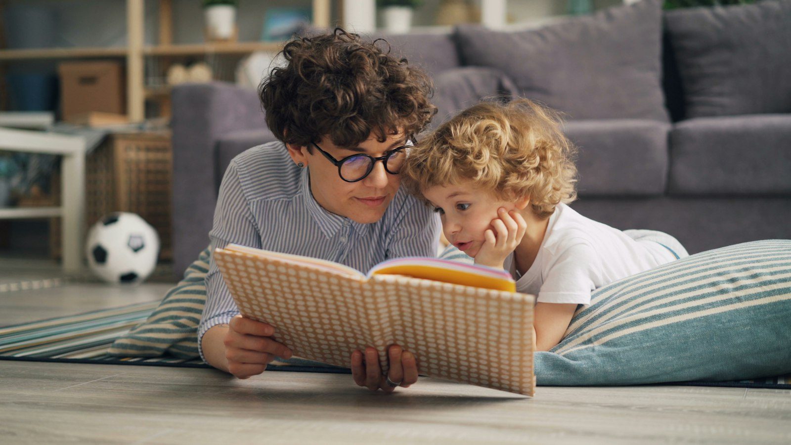 A caregiver reading a book with a child at home